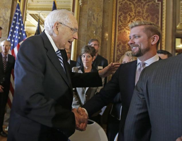 Wednesday, March 4, 2015: Elder L. Tom Perry, left, of the Church of Jesus Christ of Latter-day Saints Quorum of the Twelve Apostles shakes hands with Equality Utah executive director Troy Williams after Utah lawmakers introduced a landmark anti-discrimination bill that protects LGBT individuals while also carving out protections for the Boy Scouts of America and religious groups during a news conference at the Utah State Capitol in Salt Lake City. (AP Photo/Rick Bowmer)